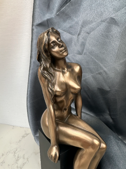 Nude girl sitting on plinth